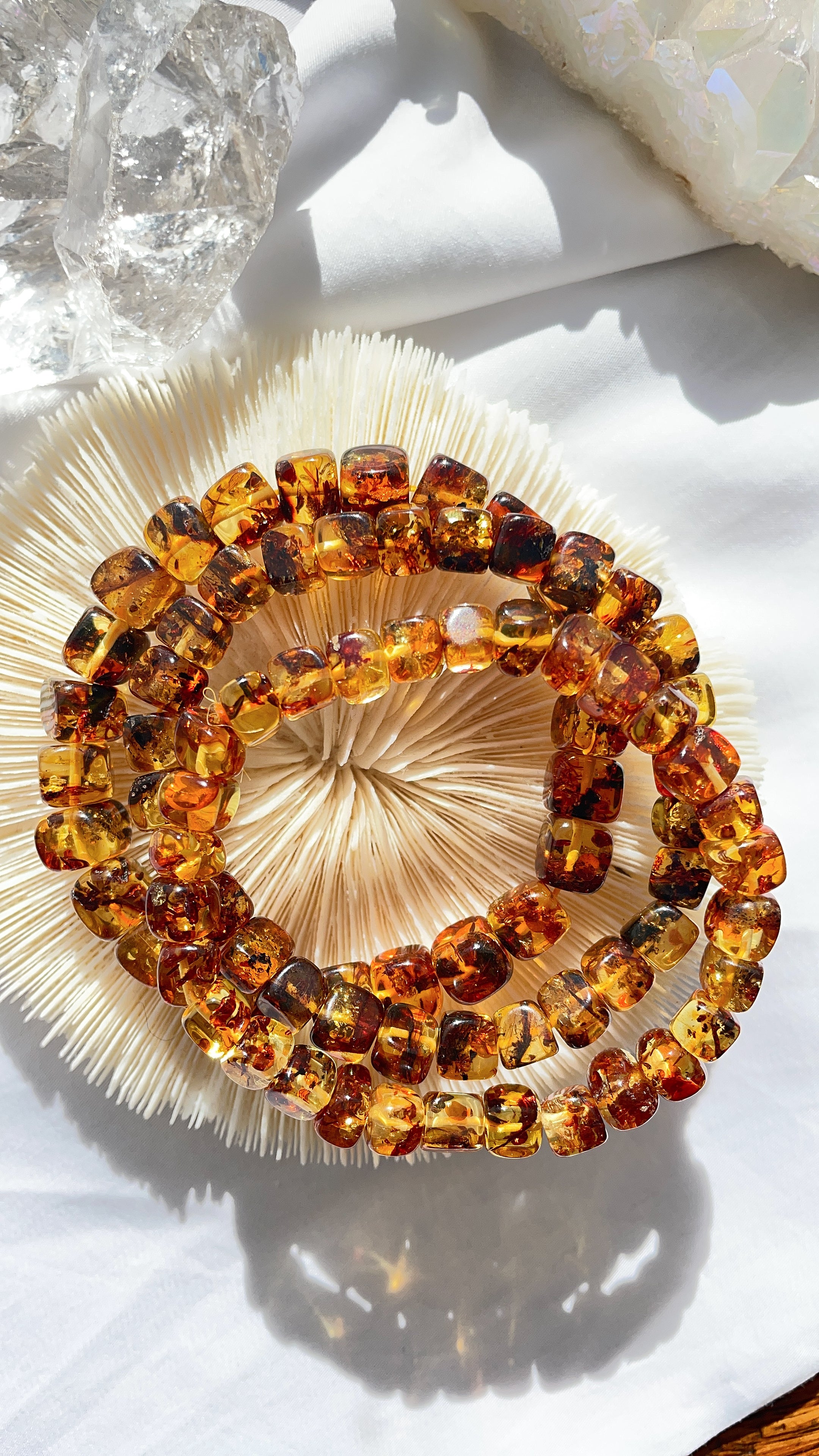 Liora natural crystal bracelets styled on a linen surface